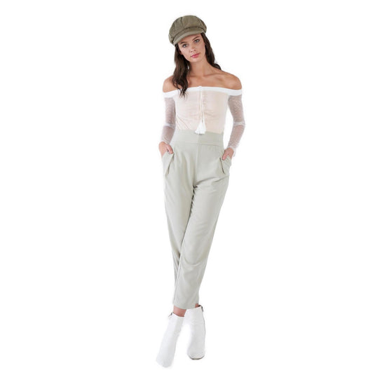 Fashion-forward woman donning ankle skinny dress pants with a sash tie waist, paired with a sheer polka dot blouse and a chic cap, presenting a sophisticated and modern ensemble.