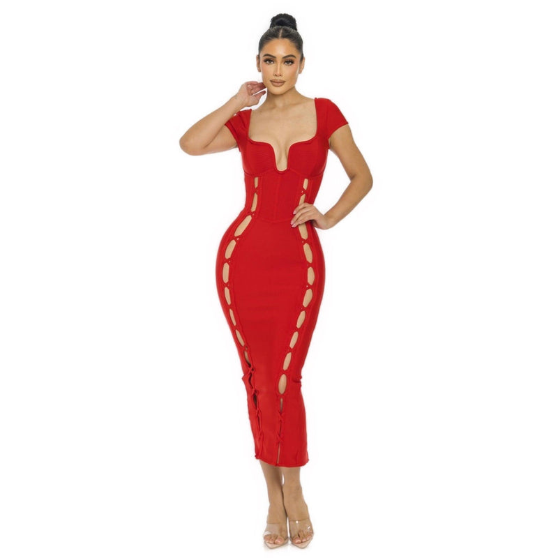 Load image into Gallery viewer, A model in a striking red Bandage Midi Slit Bodycon Dress with a sculpted wired neckline and side lace-up detailing, paired with clear high heels.
