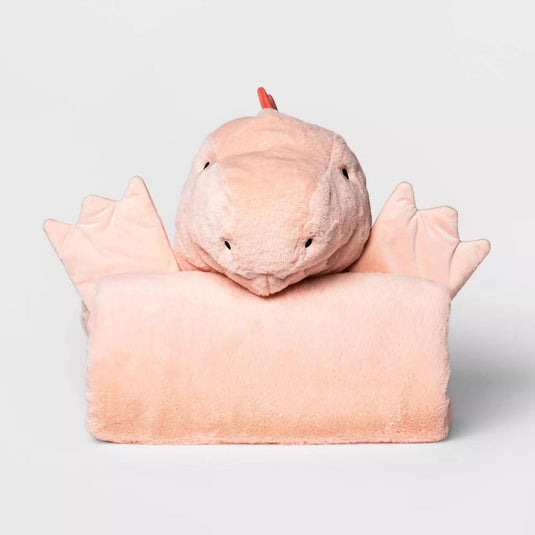 Plush pink dinosaur-themed hooded blanket folded neatly, showcasing the hood with a friendly dinosaur face, complete with eyes and a playful horn. The blanket's corner reveals charming dino spikes, hinting at the fun and creativity awaiting a child's playtime or naptime, perfect for cozy cuddles and imaginative adventures.