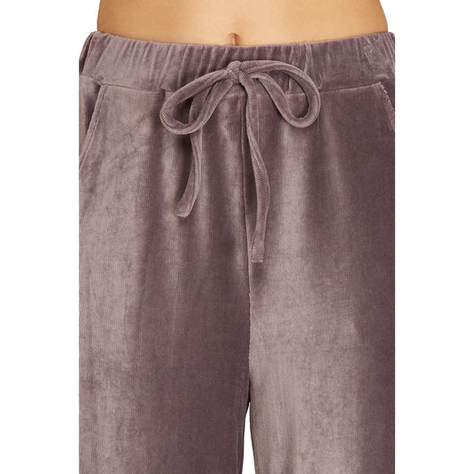 Close-up on the mauve velvet pants' elastic waistband with drawstring, showing the texture and pockets detail.