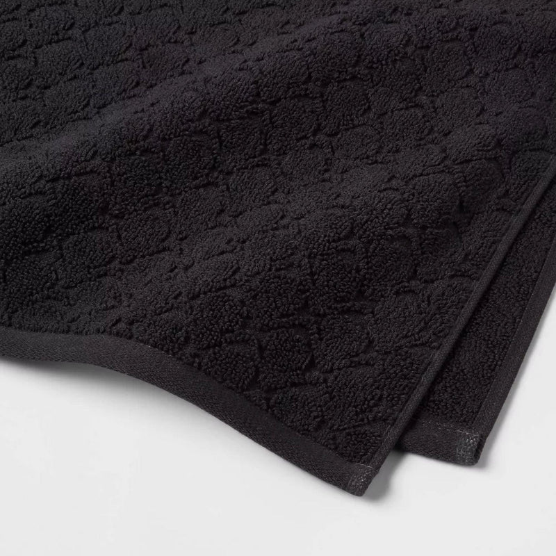 Load image into Gallery viewer, Folded black bath towel with a detailed texture, part of a six-piece set, offering a premium, soft feel for a spa-like experience at home.
