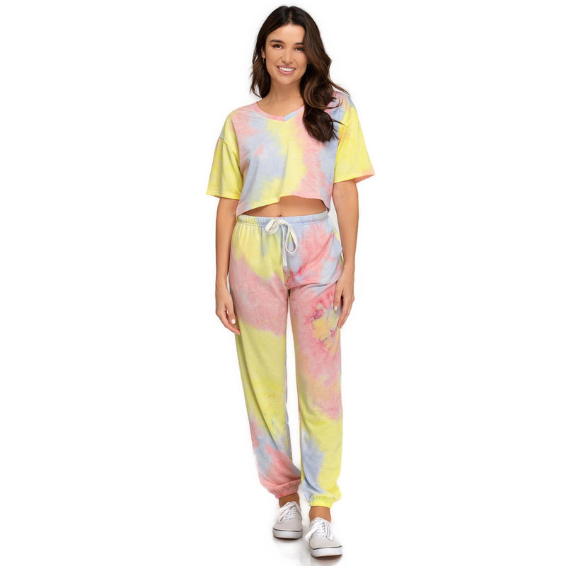 Load image into Gallery viewer, Full outfit view of a woman in matching yellow and pink tie-dyed jogger pants and t-shirt set, presenting a cohesive and trendy loungewear look. Her relaxed posture and smile reflect the outfit&#39;s comfort and playful design.
