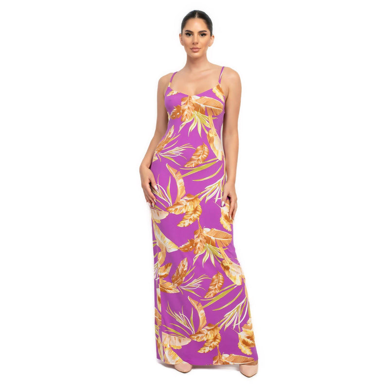 Load image into Gallery viewer, Model wearing a purple tropical print maxi dress, combining bold color with a summery floral pattern for a striking effect.
