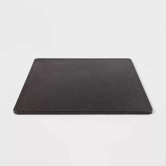 Angled view of the black polygranite cutting board, emphasizing its thick, sturdy build and the speckled granite-like finish that adds elegance to functionality.